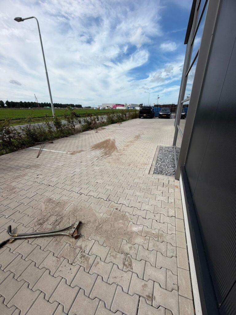 Nieuw straatwerk met klinkers bij een bedrijfspand